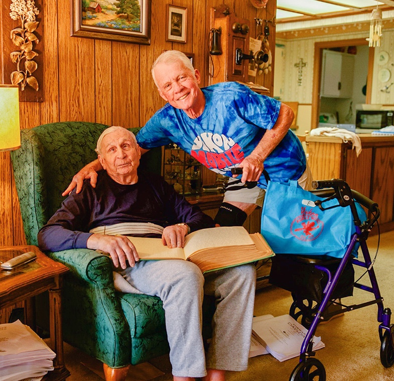 Mobile meals volunteer with meal recipient in his home