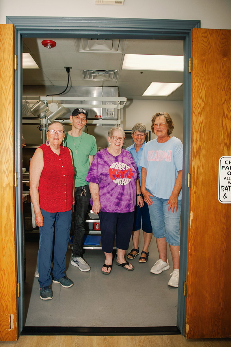 Volunteers standing and smiling in the kitchen